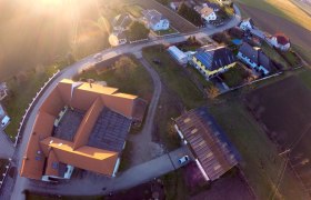 Aerial view of a village with houses, streets and fields at sunset.