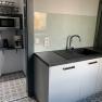 Small kitchen with sink, microwave, toaster and coffee machine.