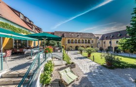 Inner courtyard of the Althof Retz with terrace, parasols and garden furniture.