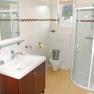 Modern bathroom with shower, washbasin and toilet.