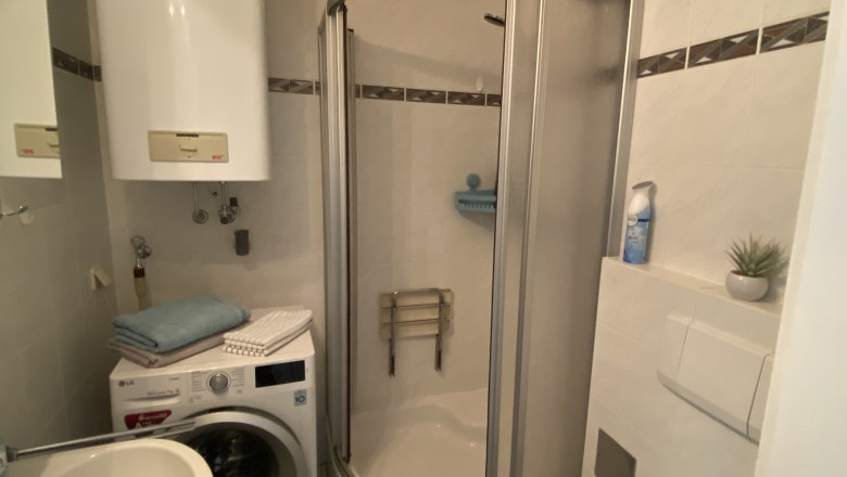 Bathroom with shower, washbasin and washing machine