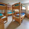 Multi-bed room with bunk beds and wooden furniture.