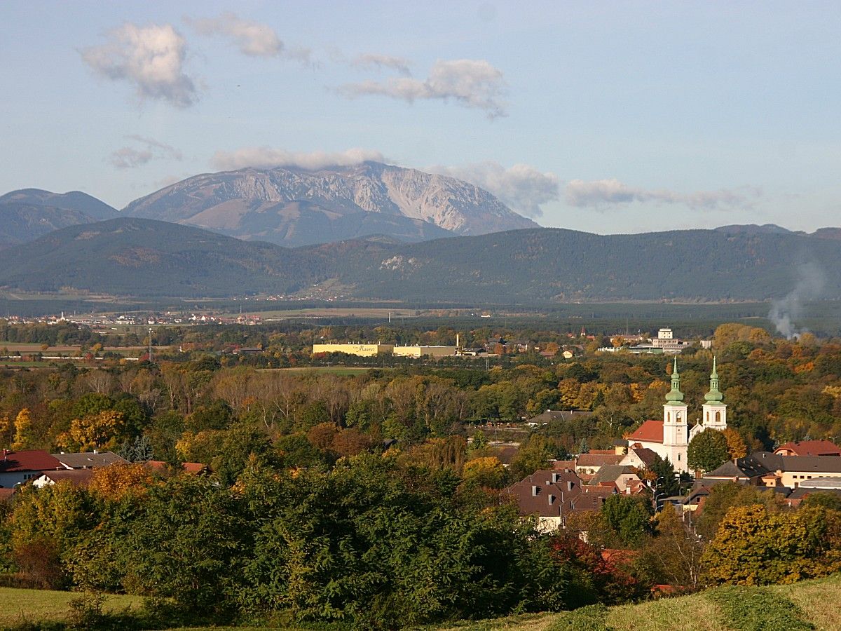 Panorama of Schwarzau am Steinfeld with church and mountains in the background.