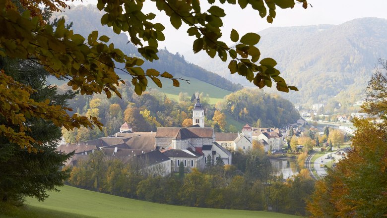 Lilienfeld Abbey in autumn with colorful foliage and surrounding hills.