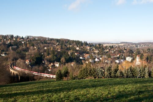 Landscape with train on viaduct in Eichgraben, surrounded by hills and houses.