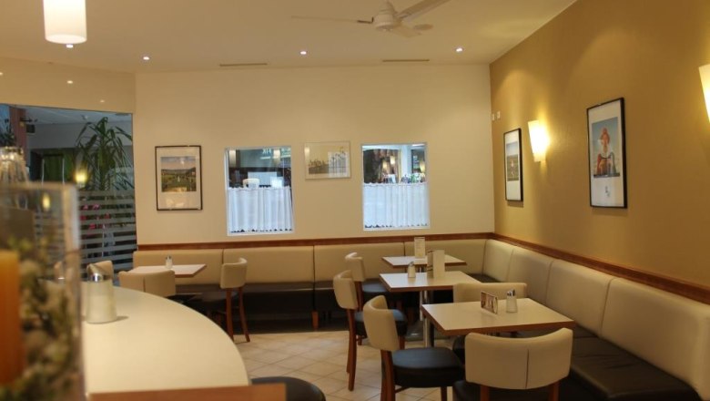 Interior view of a café with tables, chairs and wall decorations.