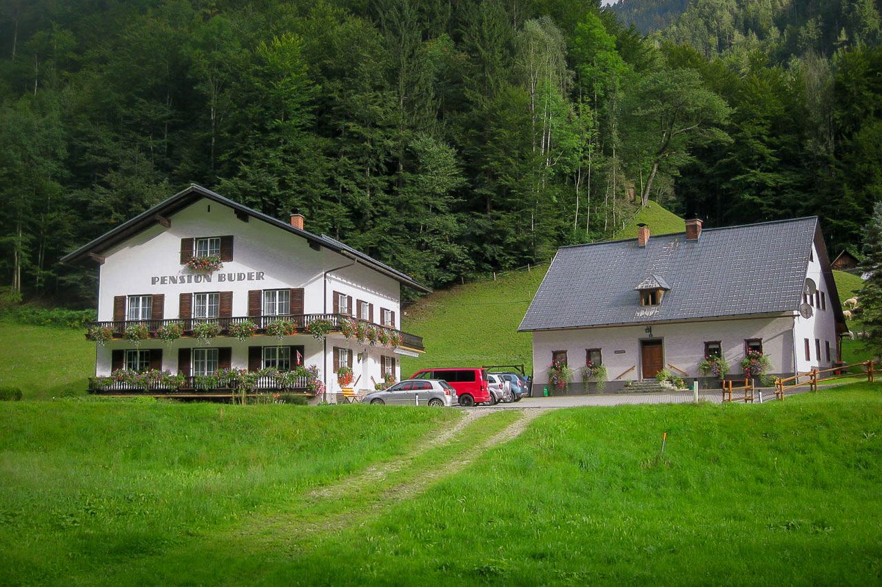 Two traditional buildings in a green, wooded setting.