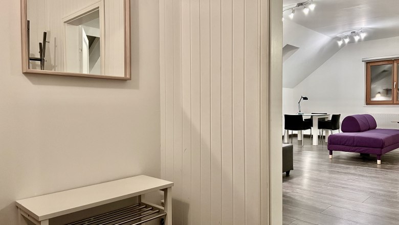 Interior view of a modern loft with purple sofa and dining table.