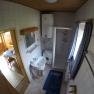 Bathroom with shower, washbasin, washing machine and blue curtains.