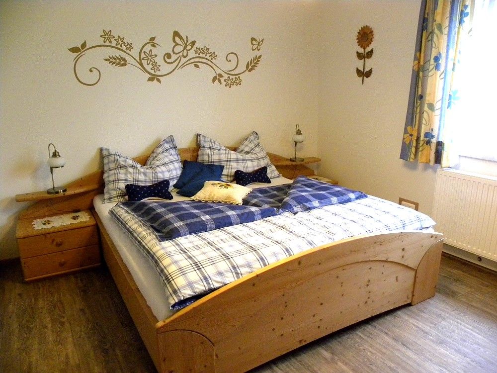 Cozy bedroom with wooden bed and blue bed linen.