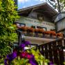 Gasthof Pension St. Wolfgang with a balcony decorated with flowers and a sign in the foreground.