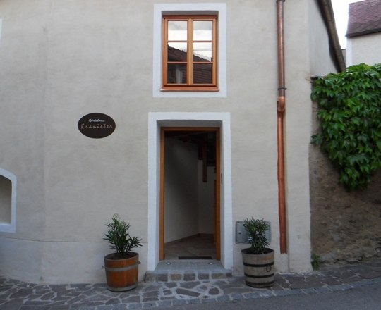 Open front door of a historic building with two flower troughs on the left and right