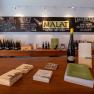 Interior view of a wine store with wine bottles and brochures on wooden tables.
