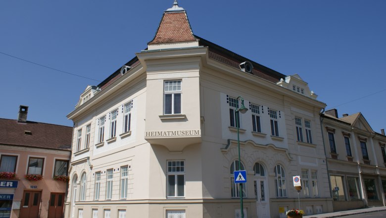 A historic building with the inscription 'Heimatmuseum' in Mank, Austria, under a clear sky.
