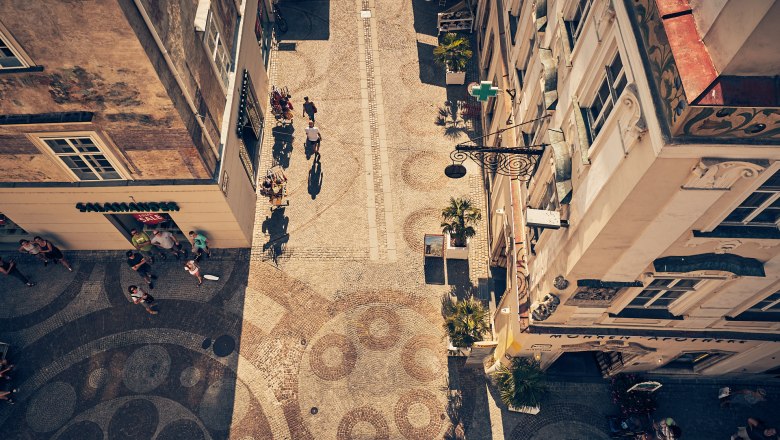 Aerial view of a cobbled street in the old town of Krems with people and stores.