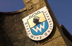 Coat of arms of the municipality of Gro&szlig;-Enzersdorf on a stone wall.