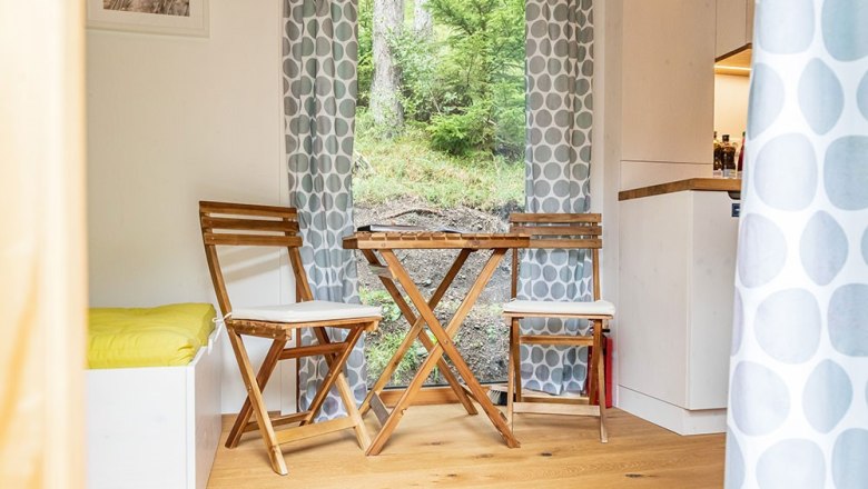 Cozy seating area with wooden furniture and a view of the greenery.