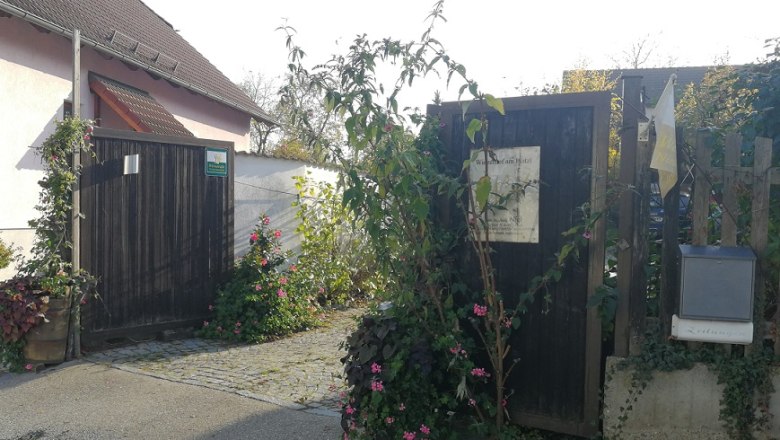 Entrance gate to a vineyard with plants and flowers.