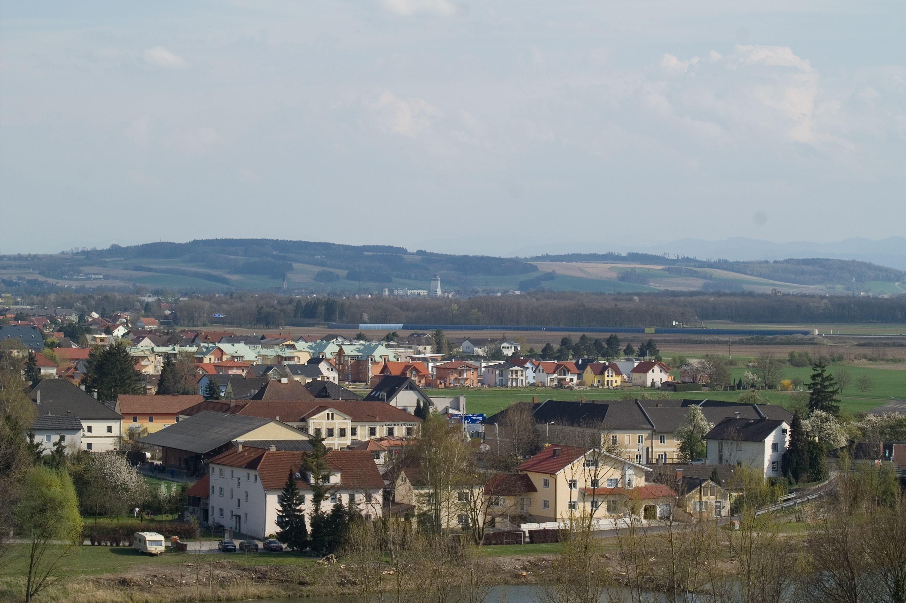 Panoramic view of Ennsdorf with houses and hills in the background.