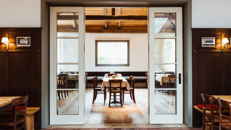 Cozy restaurant with wooden furniture and large windows.