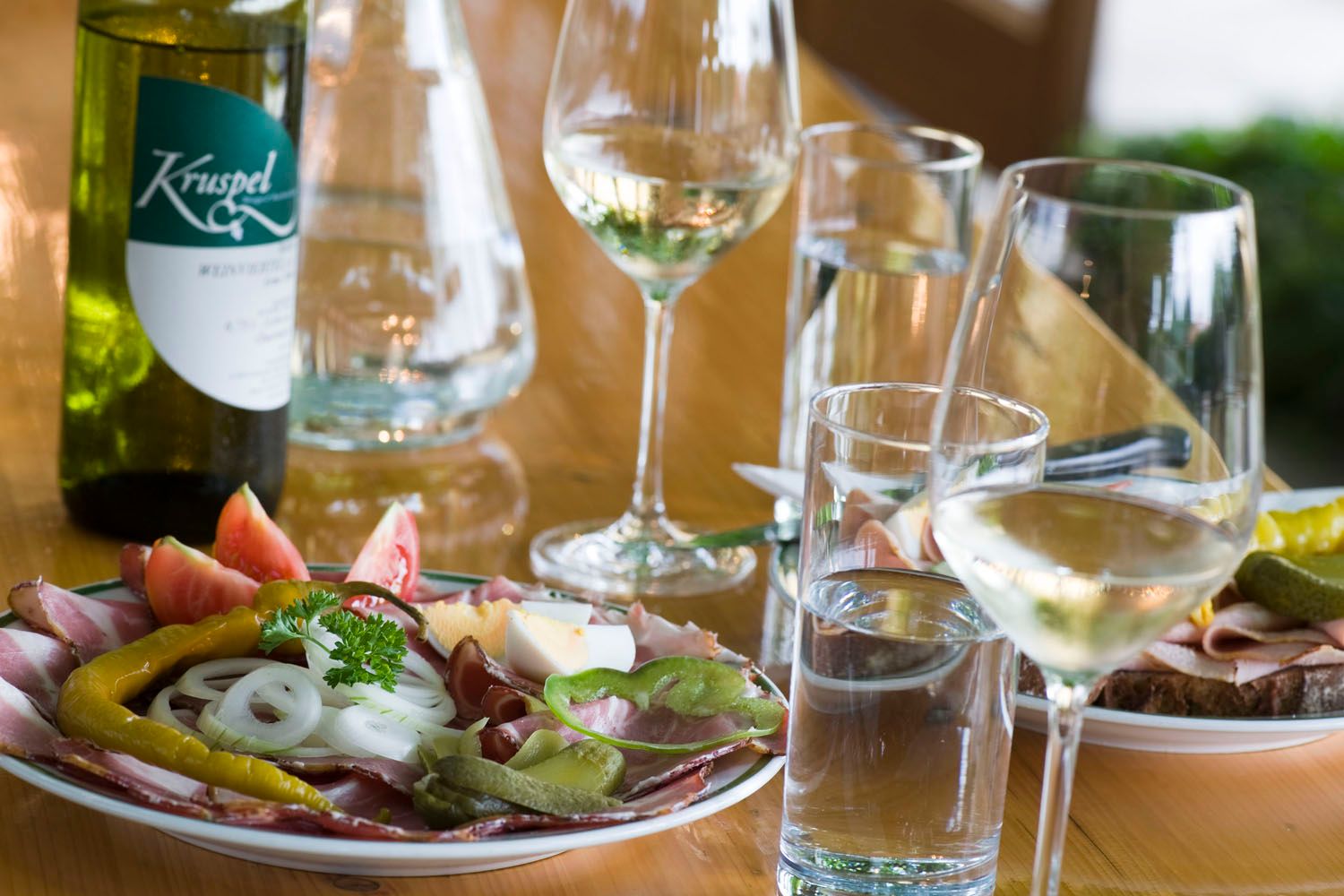 A laid table with a Heurigen snack, wine and water.