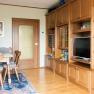 Comfortable living room with wooden furniture, dining table, chairs and a large cupboard with TV.