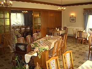 A cozy dining room with wooden furniture and decorated tables.