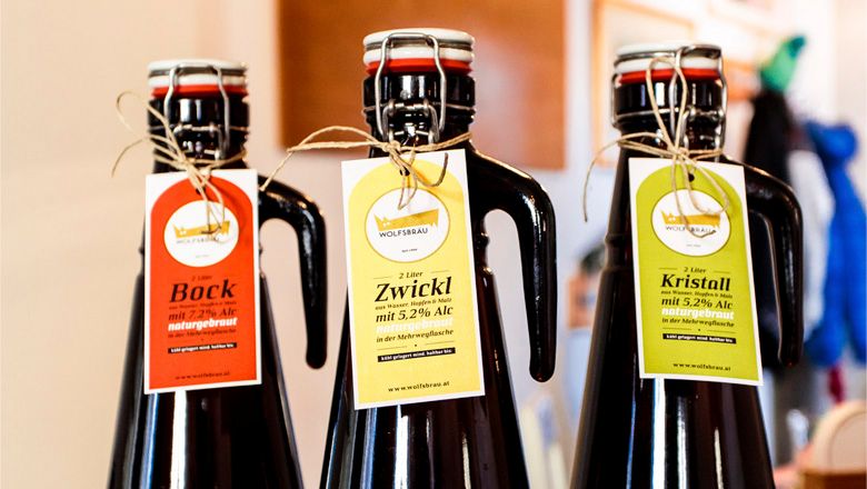 Three beer bottles with Wolfsbräu labels: Bock, Zwickl and Kristall.