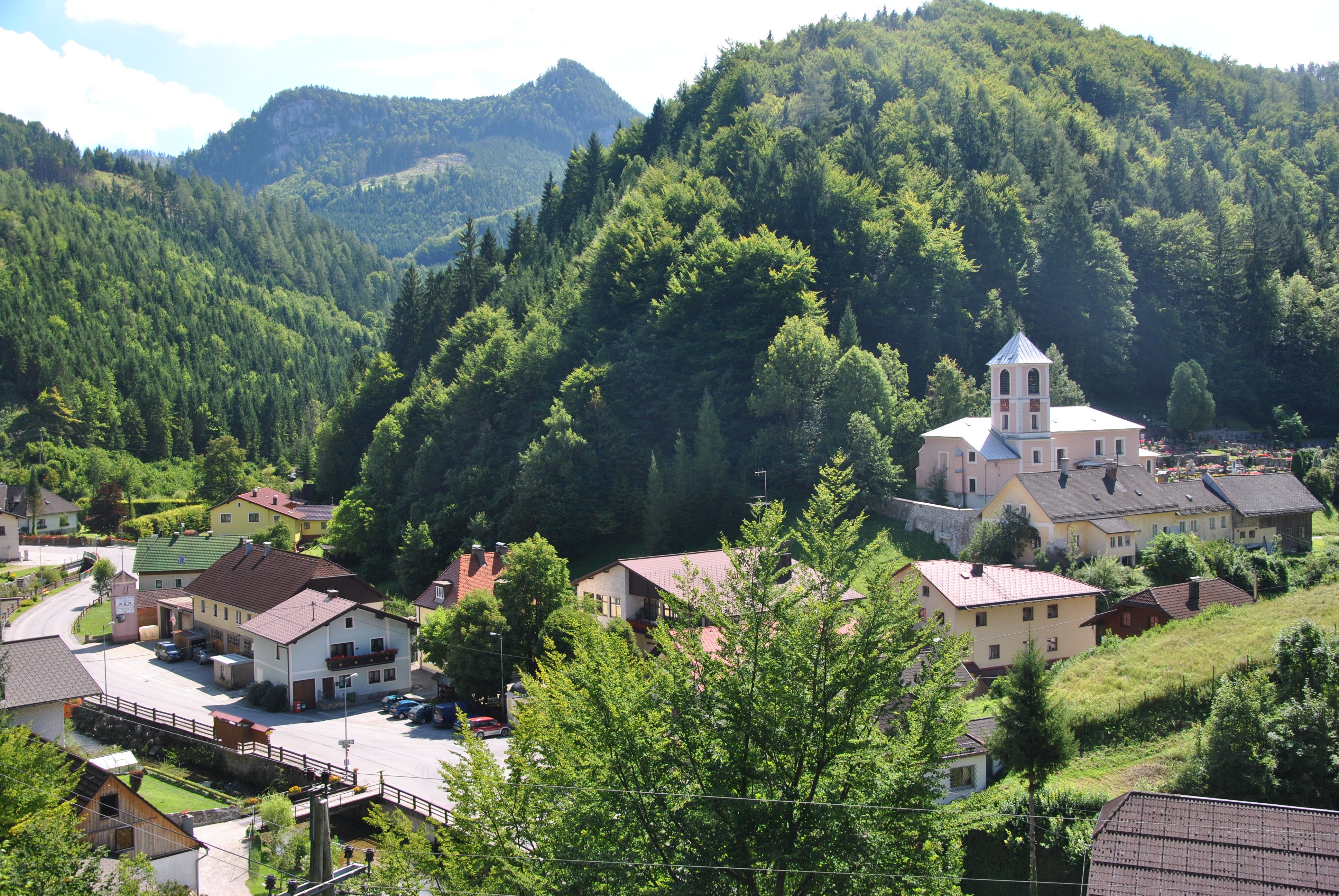 Small village in a green mountain landscape with a church and houses.