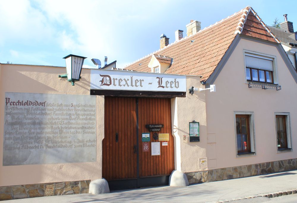 Traditional building with 'Drexler-Leeb' sign and wooden gate.