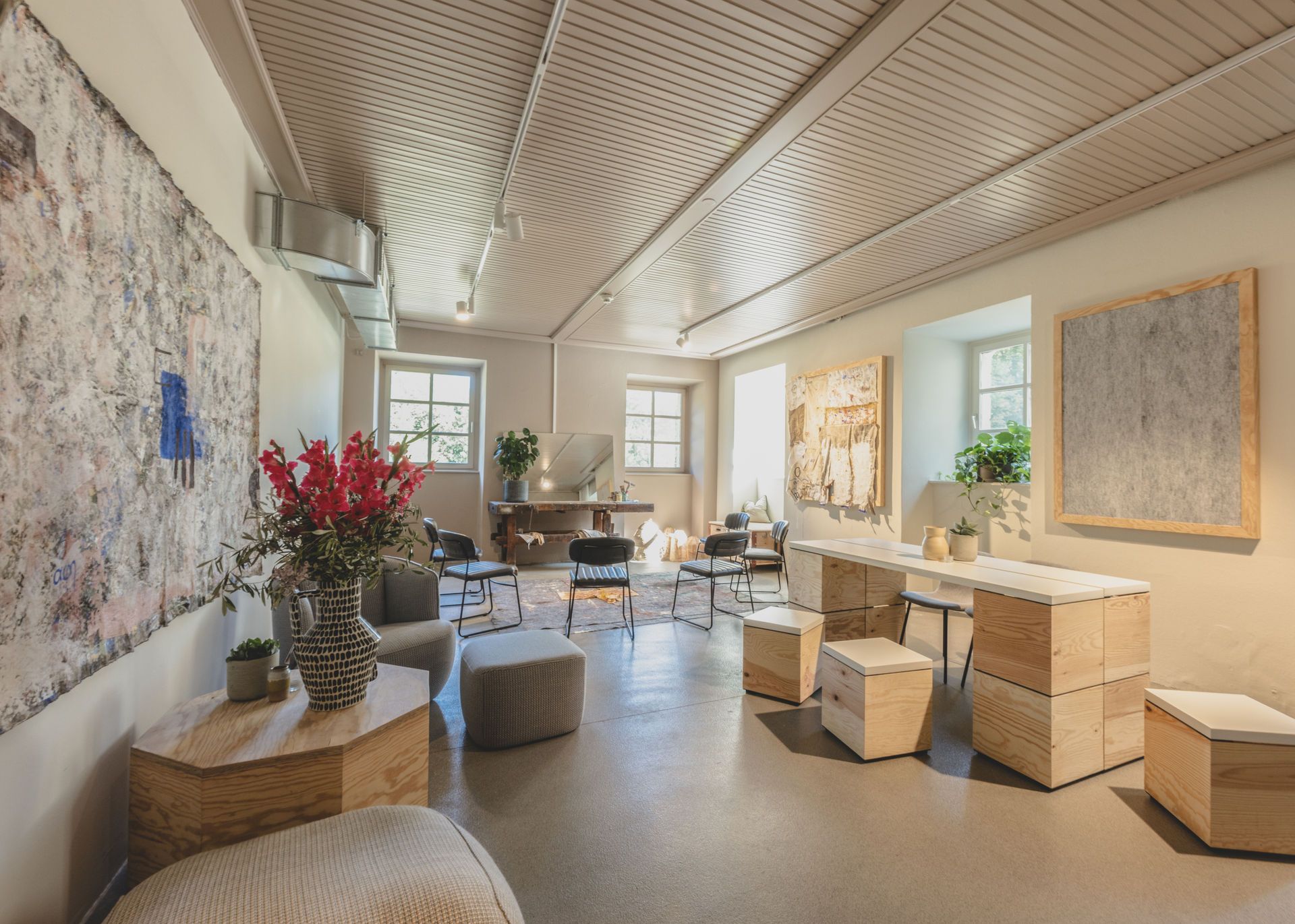 A stylishly furnished room with modern furniture, plants and works of art on the walls.