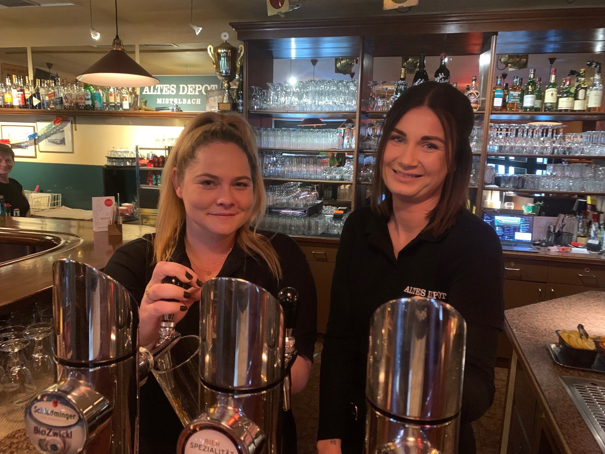 Two women behind a bar in the Old Depot, Mistelbach.