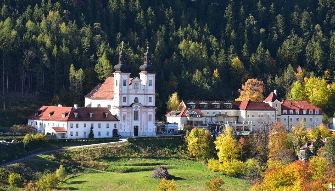 Maria Schutz basilica surrounded by autumn trees and forest.