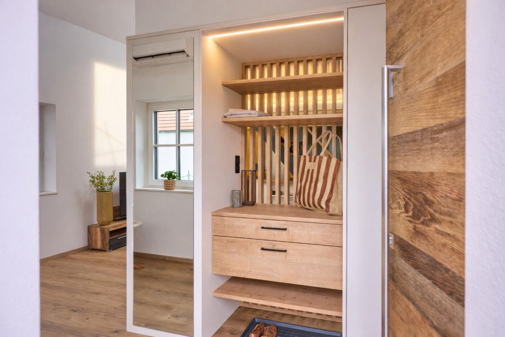 Modern entrance area with wooden details and mirror.