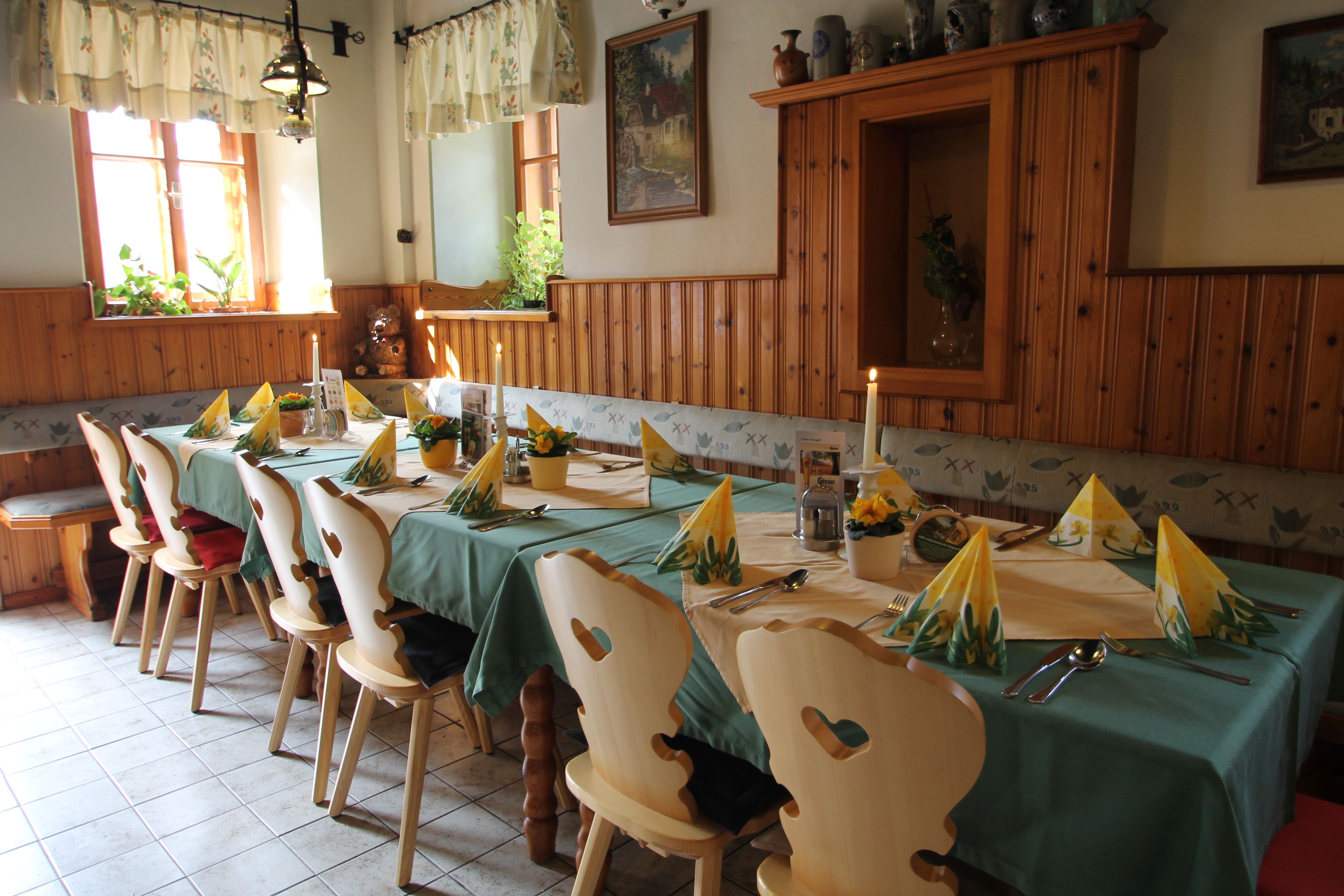 Cozy dining room with set table, wooden chairs and decoration.