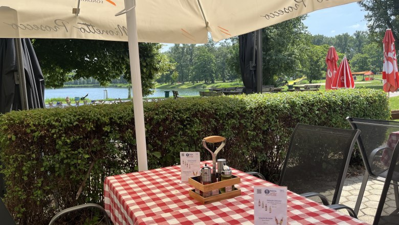 Set table with red tablecloth. In the background a hedge and the Aubad.