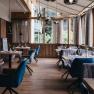Elegant restaurant with wooden floors, large windows and stylishly laid tables.