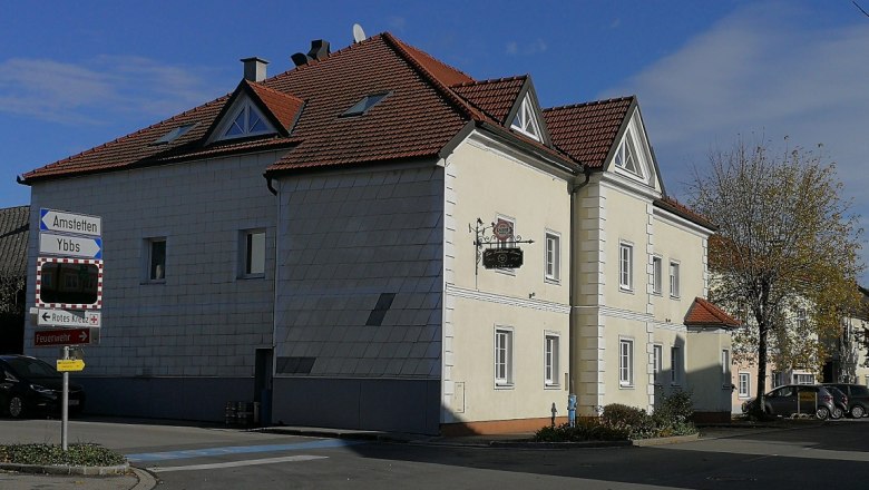 A two-storey building with a red roof and a sign saying 'Gasthaus Pitzl'.
