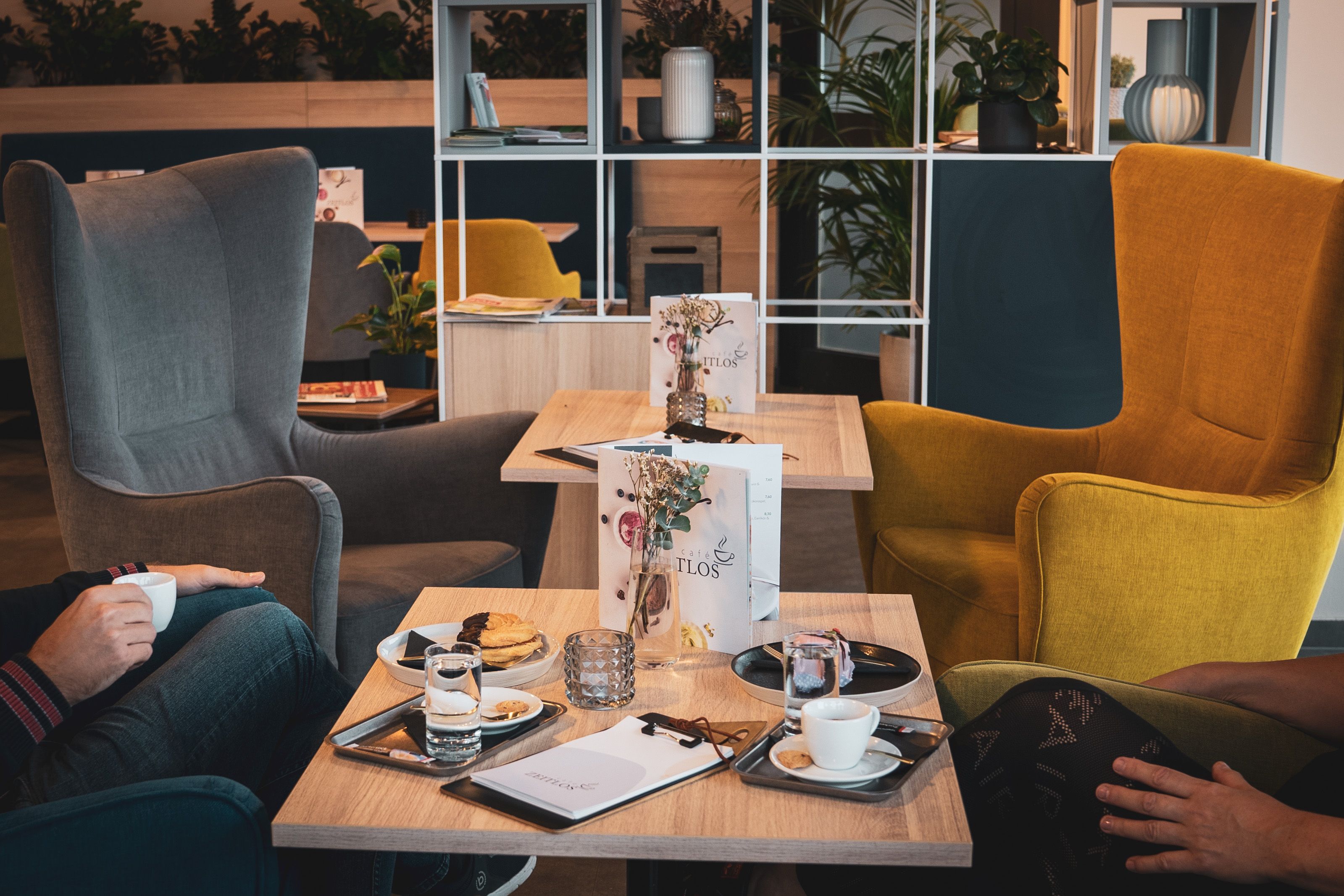 Café table laid with coffee and pastries. The café in the background.
