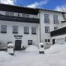 Winter view of a guest house covered in snow.