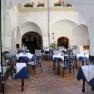 Inner courtyard of a restaurant with laid tables and striped chairs.