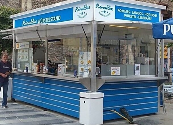 A blue snack stand called Rinalda's sausage stand with offers such as chips and hot dogs.