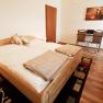 A cozy double room with wooden floor, double bed, desk and chairs.