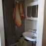 Small bathroom with shower, washbasin and towels.