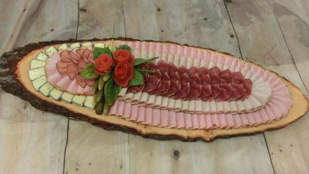 Artfully arranged platter with sausage and cheese on a wooden board.
