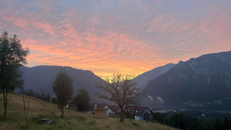 View of a house in a mountain landscape at sunset.