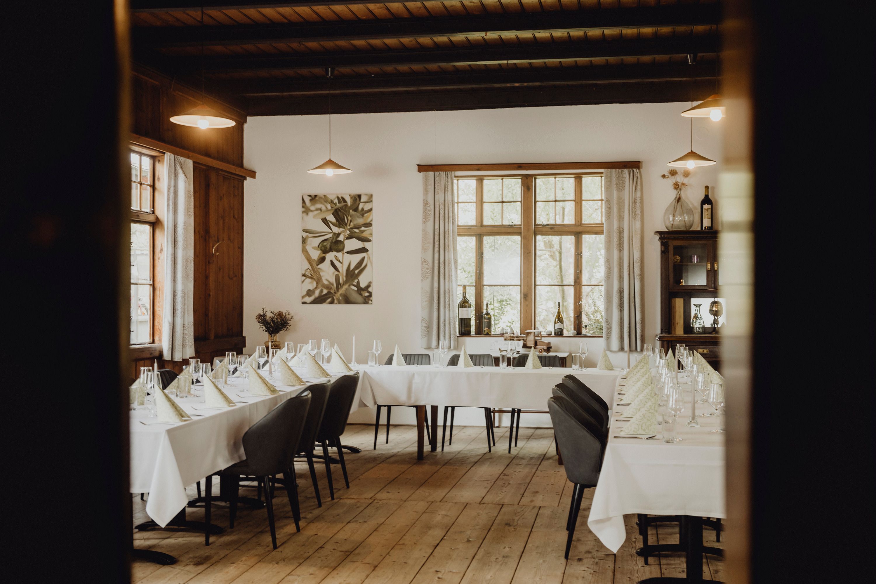 Elegant restaurant with covered tables and wooden floor.