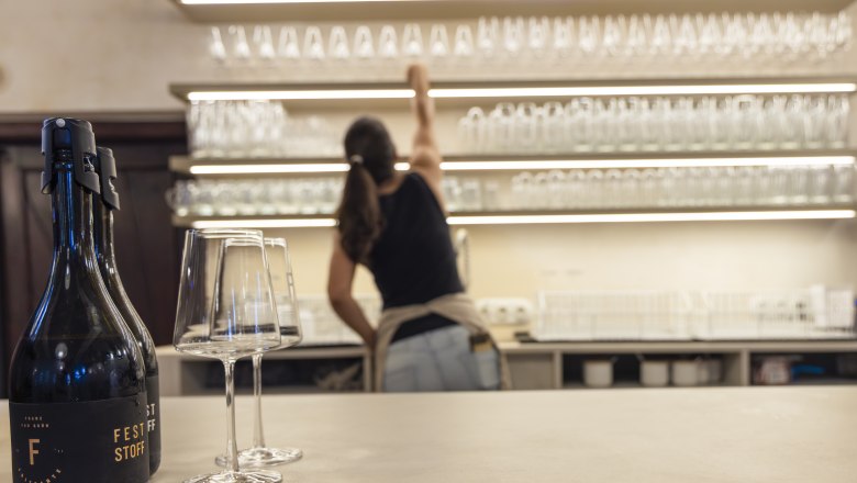 Bar area in the Heuigenlokal, wine bottle and wine glasses