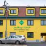 Yellow building with the inscription 'Landhaus Storch', cars parked in front of it.