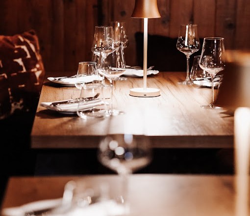 Elegant restaurant table with wine glasses and table lamp.